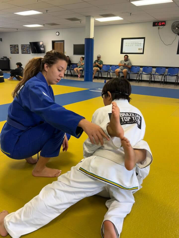 Coach working with young student during kids class